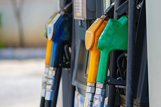 Closeup of gas pump with four different colored handles.